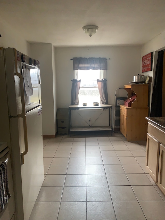 kitchen with light tile patterned floors and freestanding refrigerator