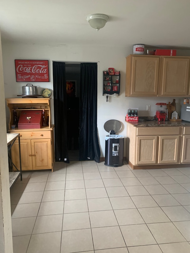 kitchen with light tile patterned floors and light brown cabinets