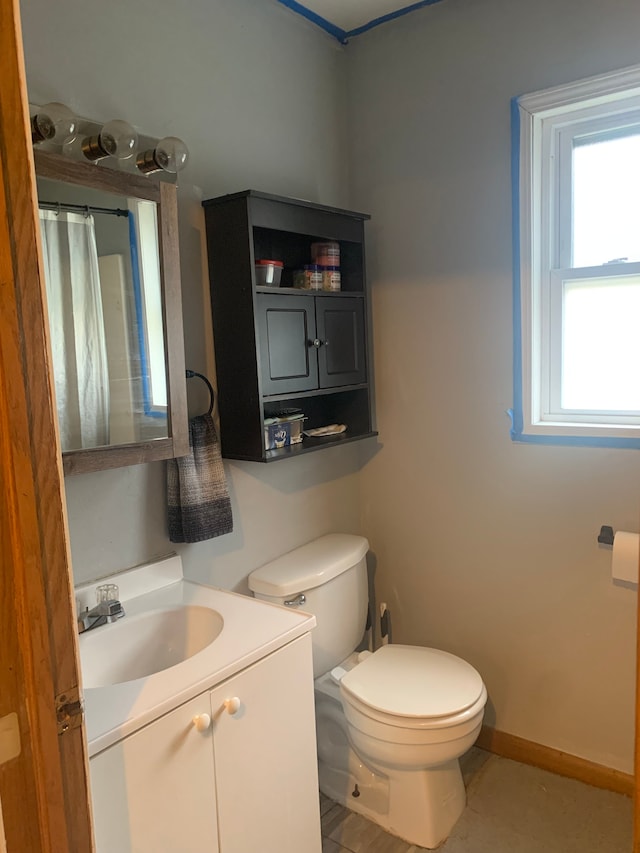 bathroom with a shower with curtain, vanity, toilet, and baseboards