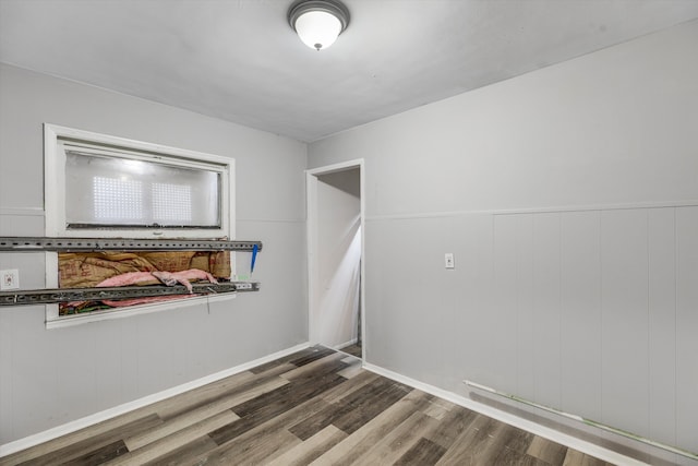 spare room featuring wood finished floors and wainscoting