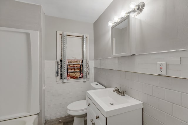 bathroom with toilet, wainscoting, wood finished floors, and vanity