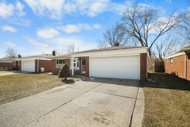 ranch-style house featuring concrete driveway, an attached garage, brick siding, and a chimney