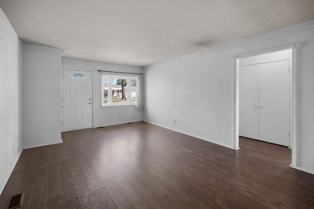 interior space featuring visible vents, baseboards, and dark wood-type flooring