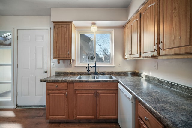 kitchen featuring dark countertops, dishwasher, brown cabinetry, and a sink