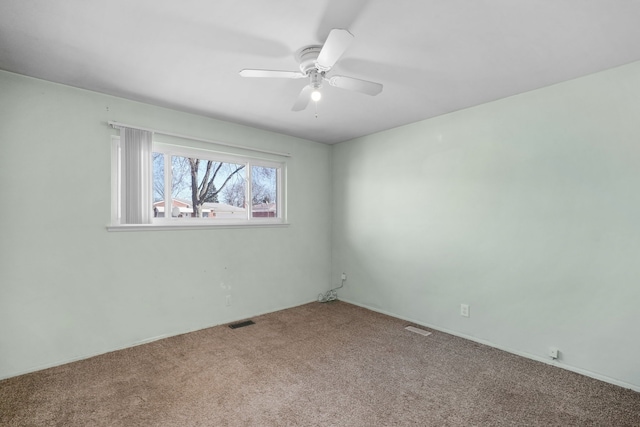 carpeted empty room with visible vents and a ceiling fan