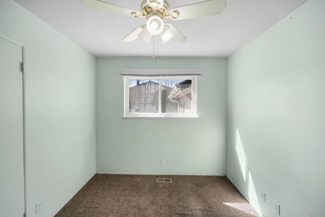 carpeted empty room featuring visible vents and a ceiling fan