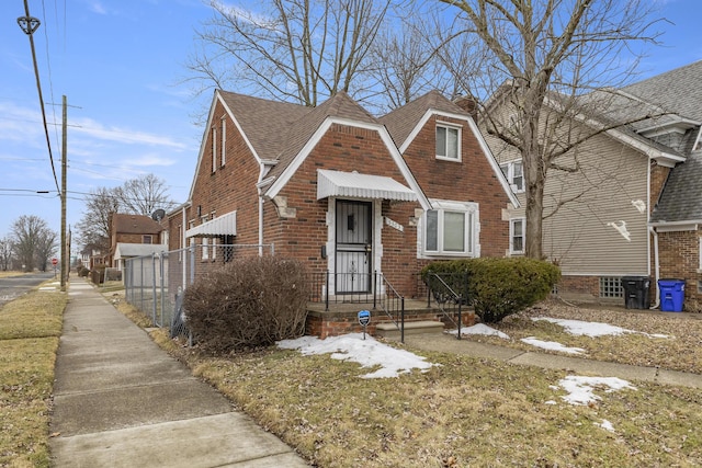 view of front of house with brick siding and roof with shingles