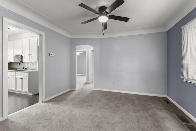 spare room featuring baseboards, visible vents, arched walkways, and carpet flooring