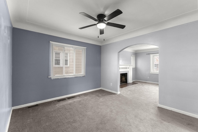 unfurnished living room featuring a fireplace with flush hearth, visible vents, carpet floors, and baseboards