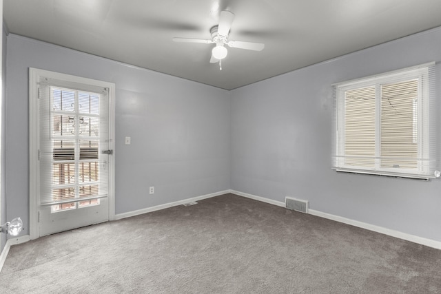 spare room featuring ceiling fan, carpet floors, visible vents, and baseboards