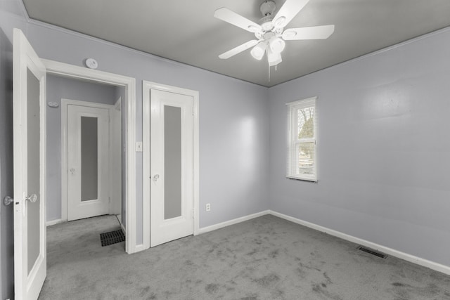 spare room with ceiling fan, carpet floors, visible vents, and baseboards