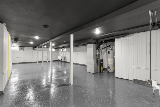 garage with heating unit, a sink, and gas water heater