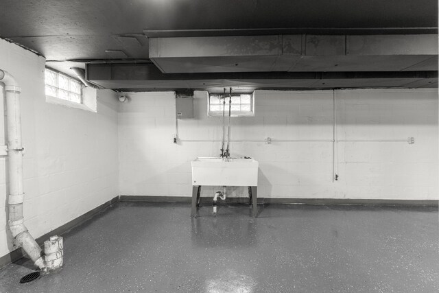 basement with concrete block wall and a sink