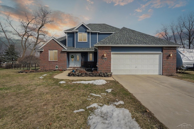 traditional-style home with brick siding, a shingled roof, a garage, driveway, and a front lawn