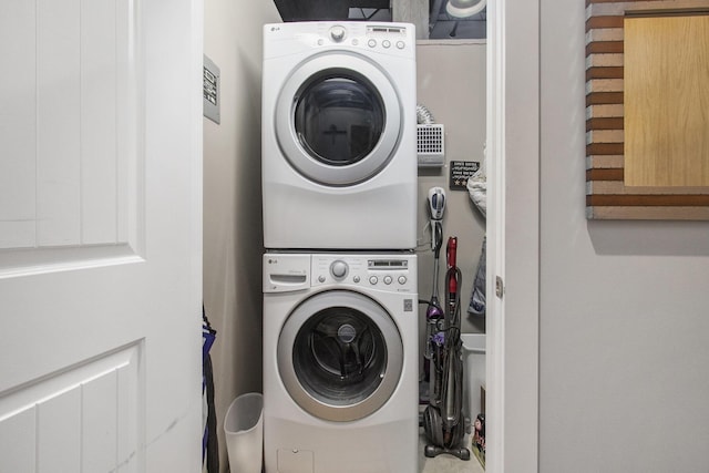 laundry area featuring stacked washer and clothes dryer and laundry area