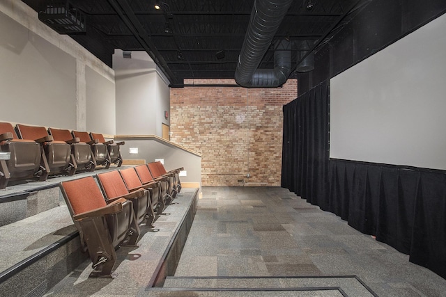 home theater with brick wall, a high ceiling, and carpet flooring