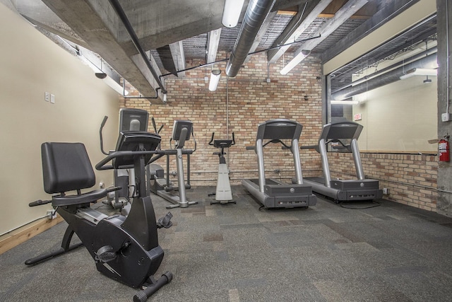 exercise room featuring brick wall