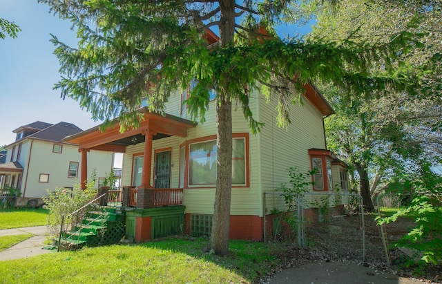 view of front of home featuring covered porch and a front lawn