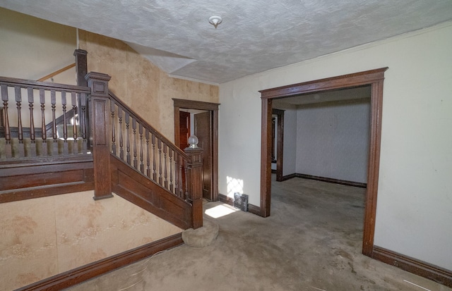 interior space with stairway, baseboards, and a textured ceiling