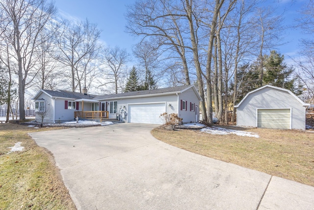 single story home featuring an attached garage, a front yard, and an outdoor structure