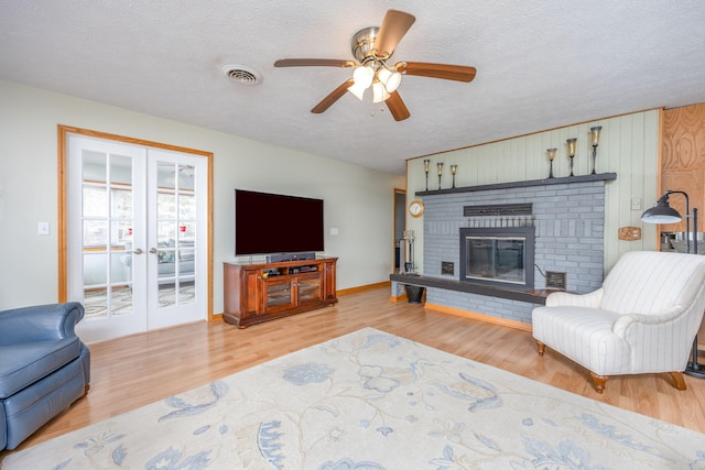 living area featuring french doors, a textured ceiling, and wood finished floors