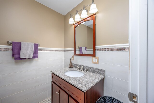 bathroom featuring a wainscoted wall, tile walls, and vanity