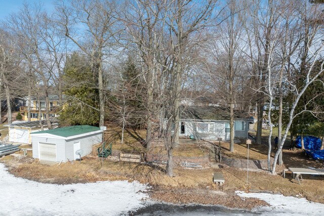 snowy yard featuring an outbuilding and a garage