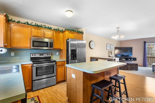 kitchen with stainless steel appliances, a center island, light countertops, and brown cabinets