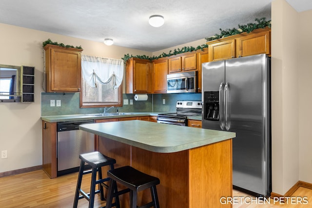 kitchen with plenty of natural light, appliances with stainless steel finishes, brown cabinets, and a sink