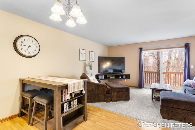 living room with a chandelier, wood finished floors, and baseboards