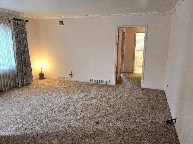 unfurnished room featuring ornamental molding, visible vents, and carpet floors