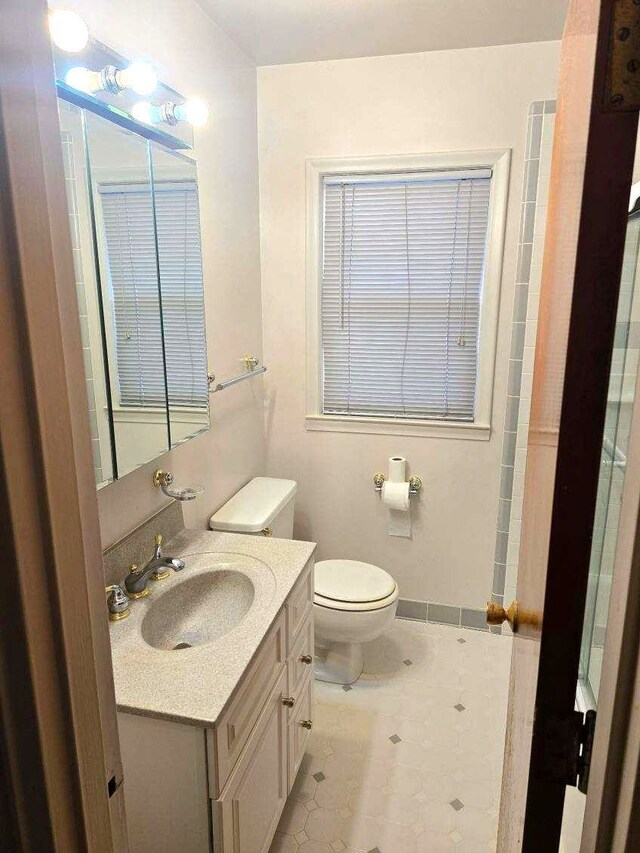 bathroom with baseboards, vanity, and toilet