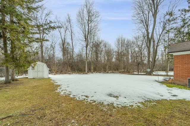 yard covered in snow featuring an outdoor structure and a storage shed