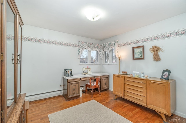 office area with light wood finished floors, baseboards, and a baseboard heating unit