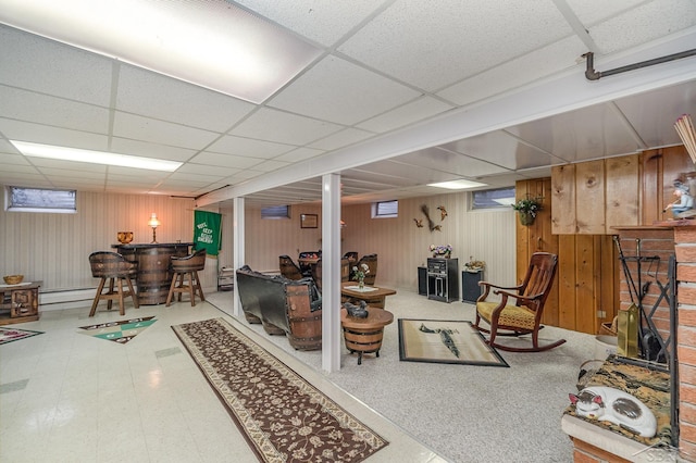 basement with a paneled ceiling, a bar, and tile patterned floors