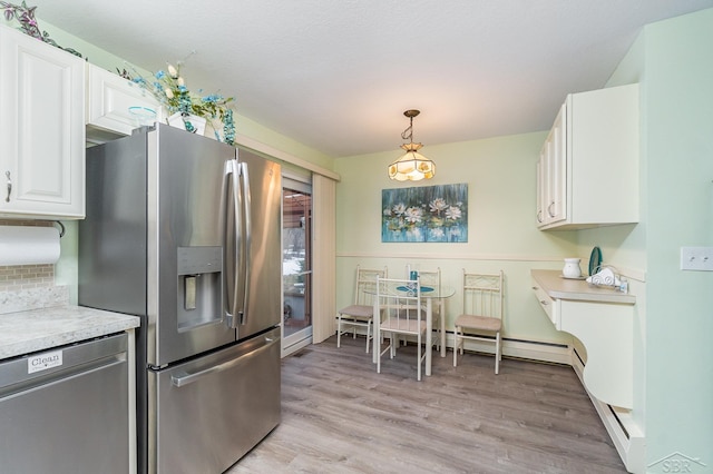 kitchen featuring light countertops, appliances with stainless steel finishes, light wood-type flooring, and white cabinets