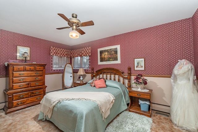 bedroom featuring ceiling fan, carpet floors, baseboard heating, and wallpapered walls