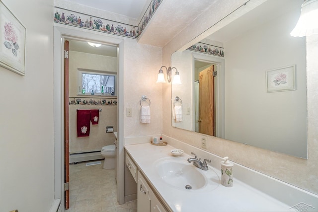 bathroom with a baseboard heating unit, vanity, and toilet