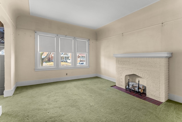 unfurnished living room with carpet floors, a fireplace, and baseboards