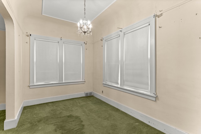 carpeted spare room with arched walkways, a chandelier, visible vents, and baseboards