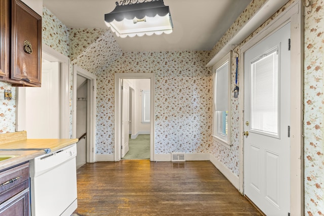 kitchen with dark wood finished floors, light countertops, visible vents, white dishwasher, and wallpapered walls