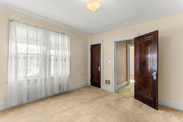 unfurnished bedroom featuring carpet, visible vents, and baseboards