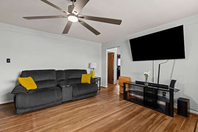 living area with baseboards, a ceiling fan, and wood finished floors