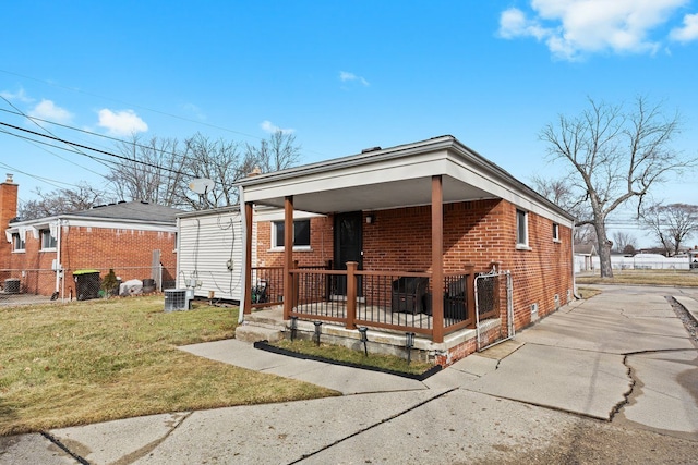 rear view of property with brick siding, a lawn, and central air condition unit