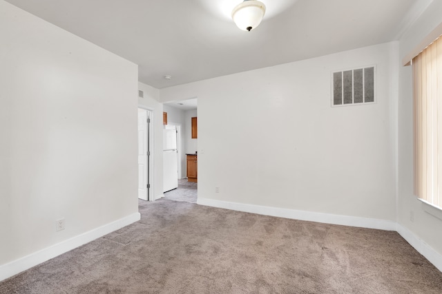 unfurnished room featuring baseboards, visible vents, and light colored carpet