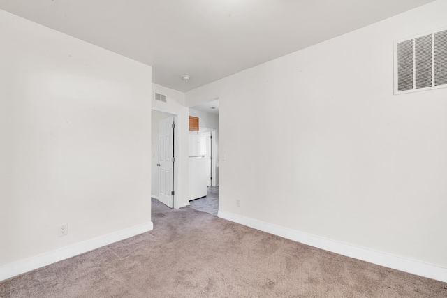 unfurnished room with carpet flooring, visible vents, and baseboards