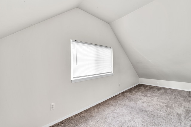 additional living space featuring vaulted ceiling, carpet flooring, and baseboards