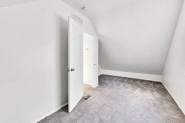 additional living space with lofted ceiling, baseboards, visible vents, and carpet flooring