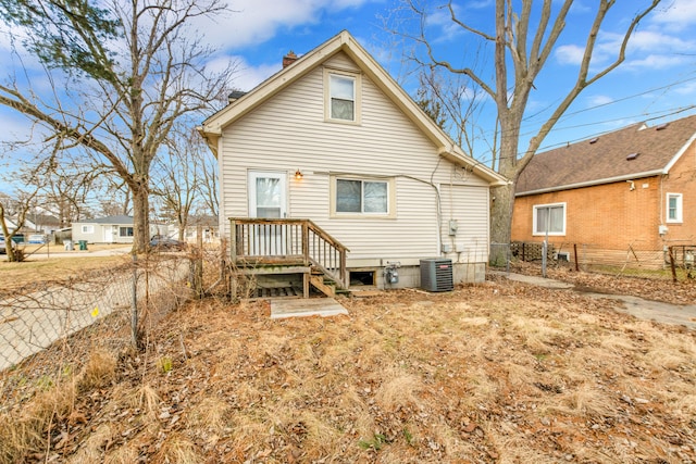 rear view of house featuring fence, a chimney, and central air condition unit