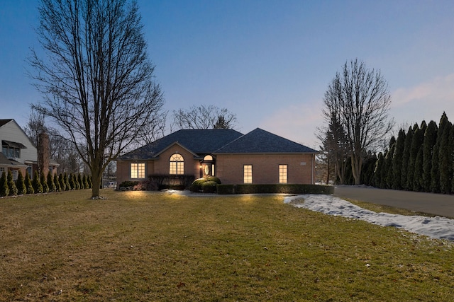 ranch-style home featuring a front yard and brick siding